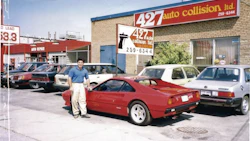 Red sports car parked outside 427 Auto Collision auto repair shop with other vehicles