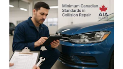 Auto technician inspecting blue vehicle using digital tablet in collision repair shop