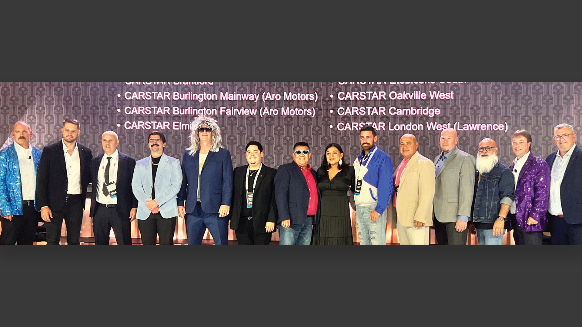 Group of diverse professionals posing at CARSTAR automotive conference event