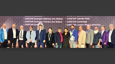Group of diverse professionals posing at CARSTAR automotive conference event