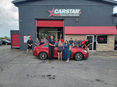 CarStar Collision & Glass Service team posing with red vehicle outside shop