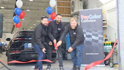 ProColor Collision ribbon-cutting ceremony with three employees and branded backdrop