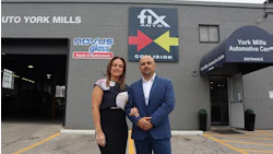 Two professionals standing in front of automotive repair and glass replacement business storefront