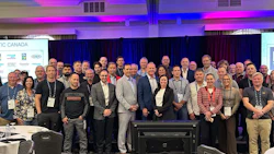 Large group of professionals gathered at an IC Canada conference event with blue and purple lighting