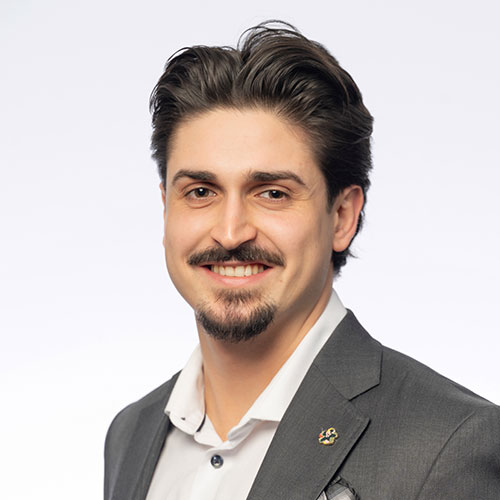 Professional portrait of a smiling man in a gray suit and white shirt