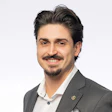 Professional portrait of a smiling man in a gray suit and white shirt