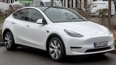 White Tesla Model Y electric SUV parked on urban street
