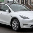 White Tesla Model Y electric SUV parked on urban street