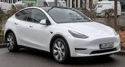 White Tesla Model Y electric SUV parked on urban street