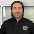 Smiling employee in black CSN Collision branded jacket
