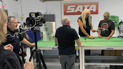 SATA video production scene with camera, green table, and team members