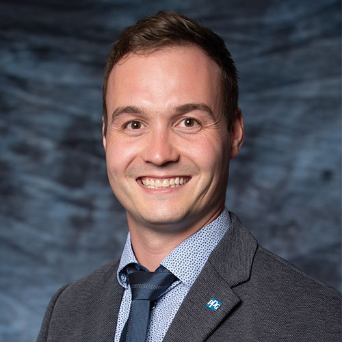 Professional smiling man in gray suit and blue tie, blurred background