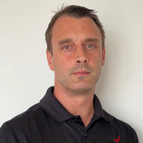 Professional man in black polo shirt against neutral background