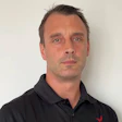 Professional man in black polo shirt against neutral background