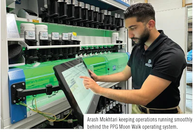 Technician operating control panel on green industrial machinery with labeled containers