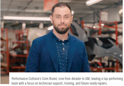 Professional technician in blue blazer standing in automotive repair workshop