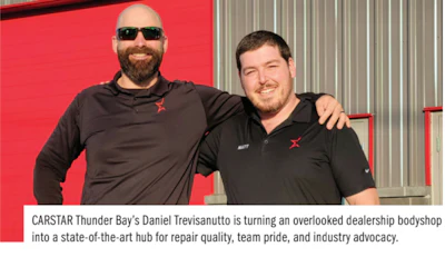 Two CARSTAR employees standing together in front of red wall, wearing black shirts