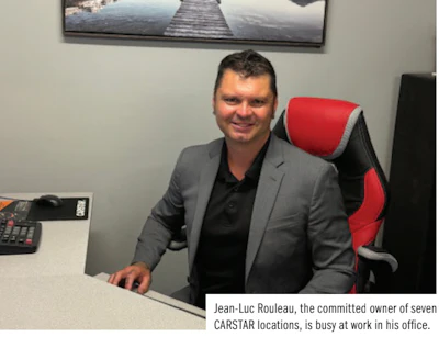 Professional man in gray blazer sitting at desk with red office chair