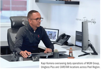 Professional working at a desk with computer, phone, and office equipment