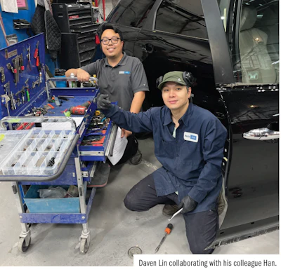 Two automotive technicians working together in a car repair garage