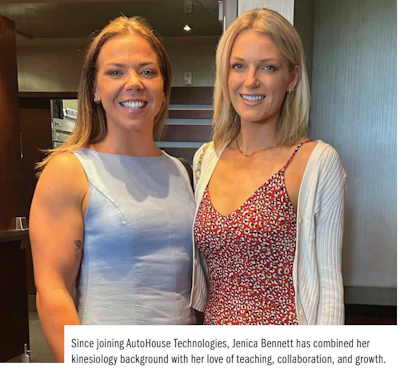 Two smiling women in professional attire standing together in an office setting