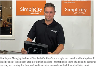 Simplicity Car Care representative holding tablet in front of company logo signs