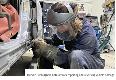 Automotive technician wearing protective gear repairing vehicle body in workshop
