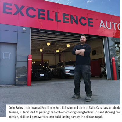 Auto technician standing in front of Excellence Auto Collision repair shop garage