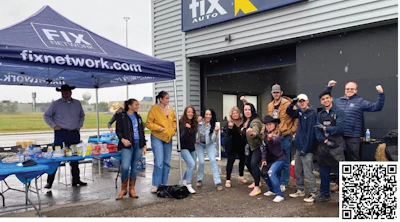 Fix Network team gathering outside auto shop with branded tent on rainy day