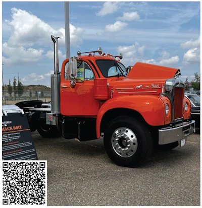 Classic bright orange vintage Mack truck at outdoor vehicle exhibition
