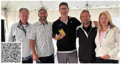 Five professionals posing together in a white tent, wearing casual business attire
