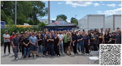 Large group of employees gathered outside at corporate team event with black branded tent