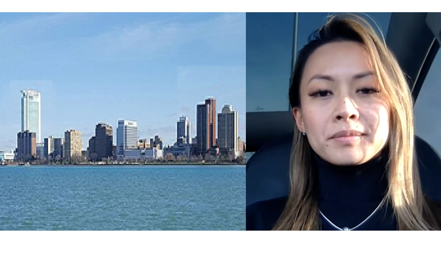 Detroit skyline with blue water and urban buildings, alongside a person in a dark top
