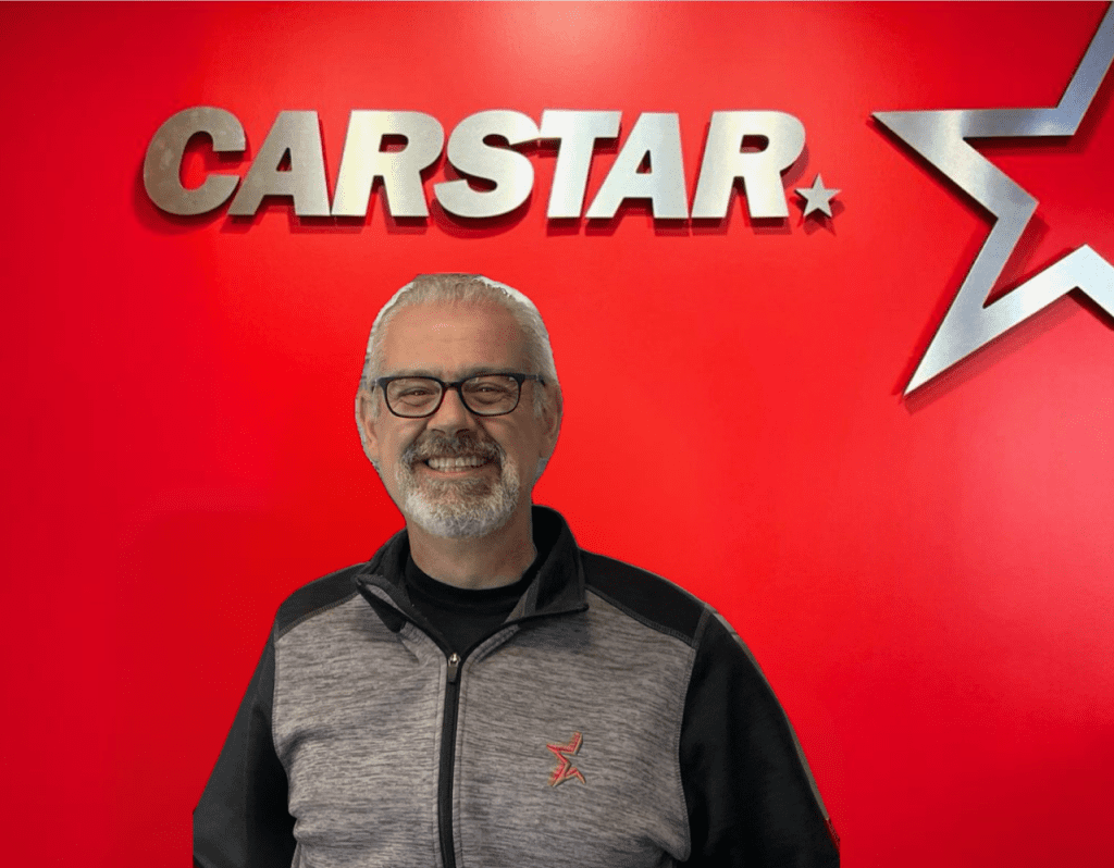 CARSTAR automotive service professional in branded gray and black jacket