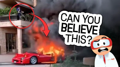 Red sports car engulfed in flames with smoke, person watching from balcony