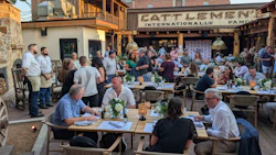 Crowded outdoor dining area at Cattlemen's restaurant with people seated at wooden tables