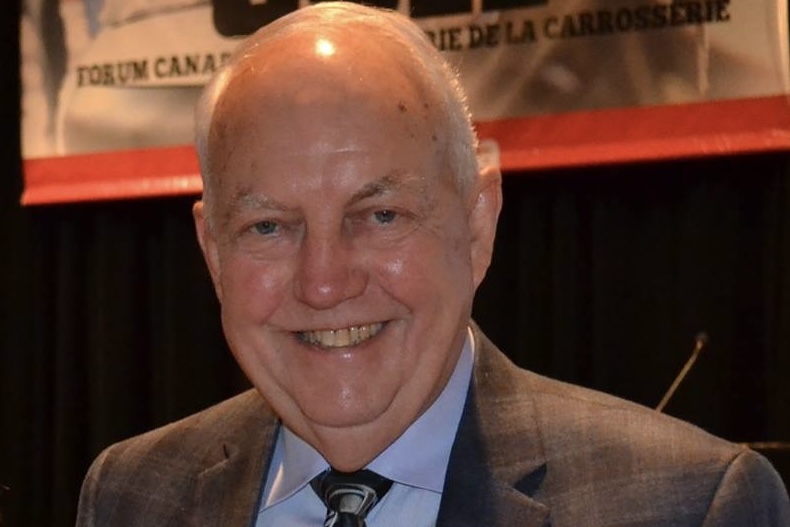 Smiling senior man in brown suit and tie at a professional event