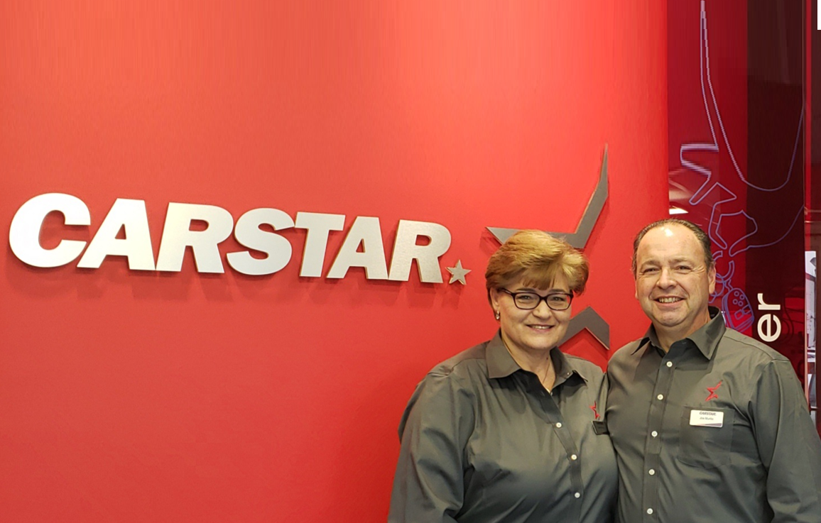CARSTAR automotive service logo with two employees in matching shirts