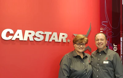 CARSTAR automotive service logo with two employees in matching shirts