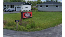 Red Original logo sign in front yard with residential houses and trees