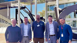 Six professionals standing together in a modern office building lobby