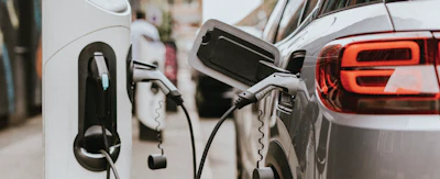 Electric vehicle charging at modern charging station with white and gray color palette
