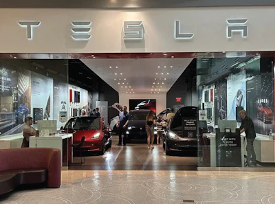 Tesla showroom interior with red and black electric vehicles on display