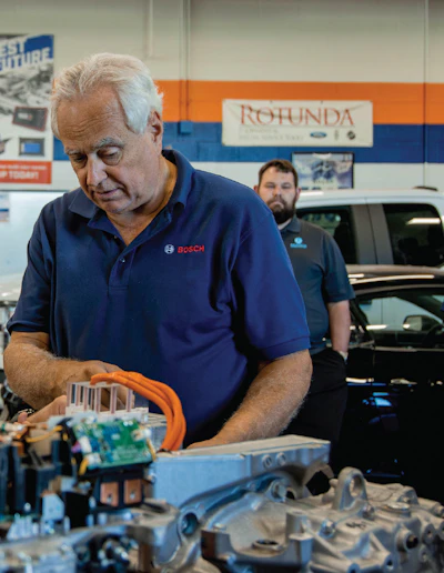 Bosch technician examining automotive electrical components in workshop