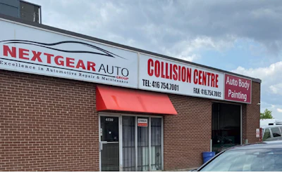 NextGear Auto Collision Centre storefront with red awning and brick exterior