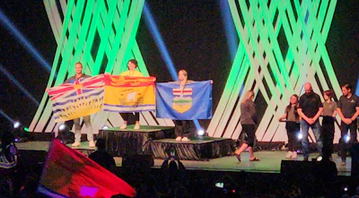 Canadian provincial flags displayed on stage during ceremonial event