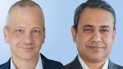 Two professional men in business suits smiling at camera