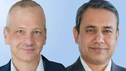 Two professional men in business suits smiling at camera