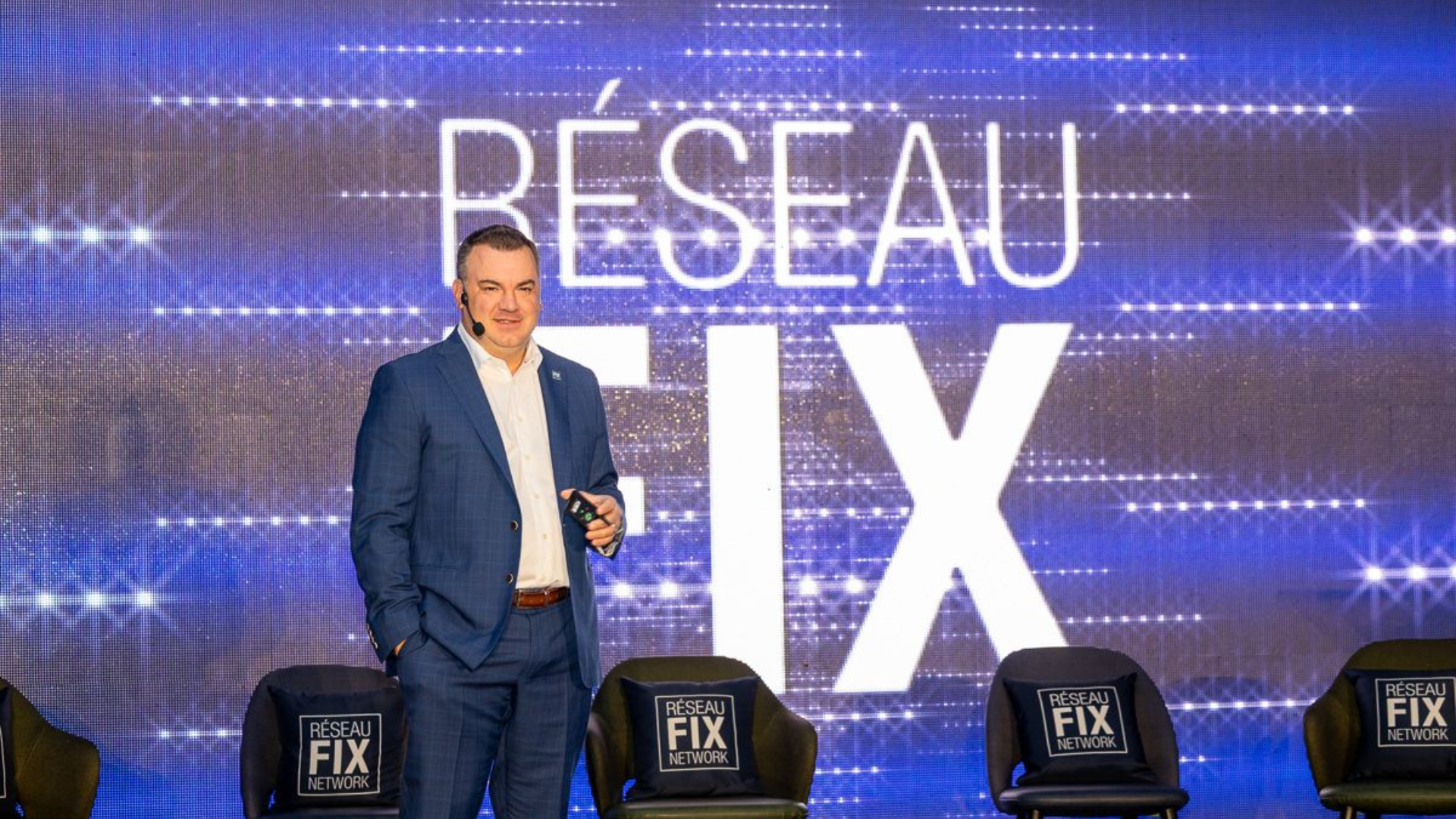 Réseau FIX corporate event stage with branded backdrop and presenter