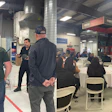 Training session in industrial workshop with attendees seated and presentation screen